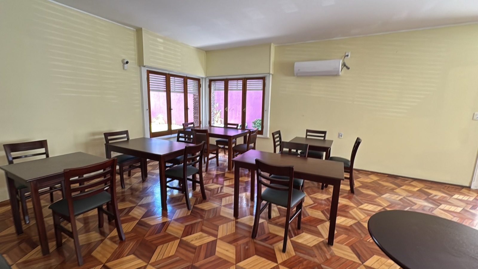 Comedor de Altos del Remanso con mesas de madera y ventanales