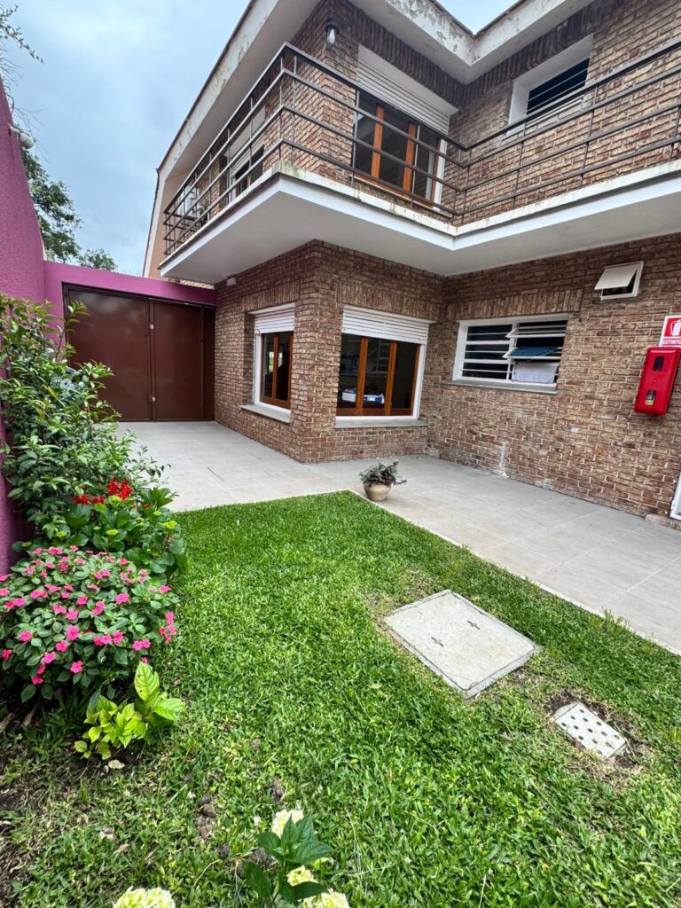 Patio con jardín y fachada de ladrillo de la residencia
